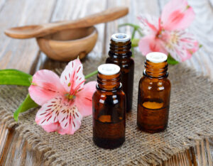 Essential oil and flowers on a brown background